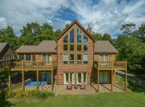 a large wooden house with a deck and a pool at Mountain Top Lodge in McHenry