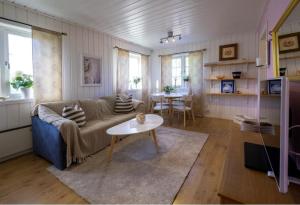 een woonkamer met een bank en een tafel bij Lilla gröna huset på gården in Härnösand