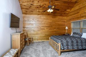 Schlafzimmer mit einem Bett und einem Deckenventilator in der Unterkunft Cedar Shores Villa 03 in McHenry