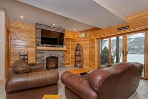 ein Wohnzimmer mit Ledermöbeln und einem Kamin in der Unterkunft Cedar Shores Villa 03 in McHenry