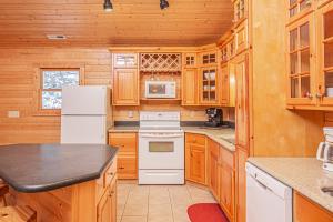 eine Küche mit Holzschränken und einem weißen Kühlschrank in der Unterkunft Viva Place in McHenry