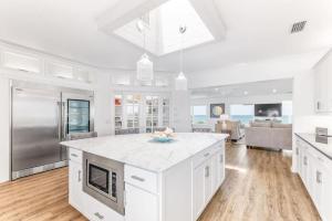 a kitchen with white cabinets and a kitchen island with a counter top at Island Time -- Oceanfront Bliss in St. Augustine
