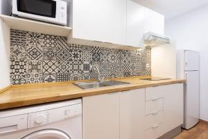 cocina blanca con fregadero y microondas en Cálido apartamento. Tenerife. WiFi., en Arafo