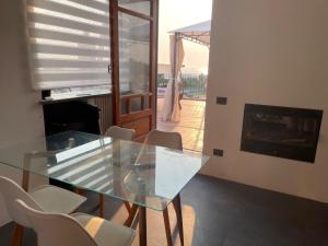a glass table and chairs in a room with a fireplace at DOMUS PARVA - Villa con bio-piscina, spa privata e appartamenti panoramici in Bacoli