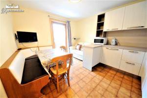een kleine keuken met een tafel en een bank in een kamer bij Appartamenti Barin by Livigno Accomodation in Livigno +4 foto's