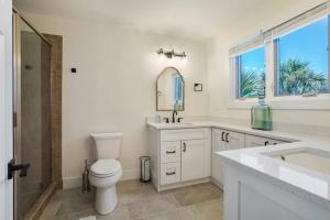 a bathroom with a toilet and a sink and a mirror at Crescent Lookout Oceanfront with panoramic views in St. Augustine +45 photos
