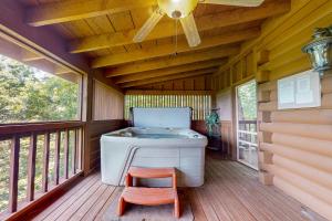 a soaking tub on a porch with a chair and a ceiling at Fantasy Mountain View in Sevierville