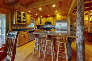 a kitchen with yellow cabinets and a island with bar stools at Fantasy Mountain View in Sevierville