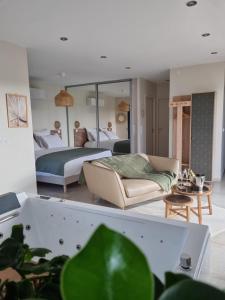 a bedroom with two beds and a living room with a couch at La Suite in Brie