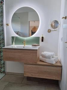 a bathroom with a sink and a mirror at La Suite in Brie