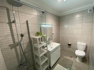 a bathroom with a shower and a toilet and a sink at Elegance 15 minutes from Lisbon! in Montijo