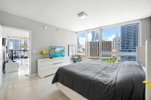 um quarto branco com uma cama e uma grande janela em Icon Brickell Miami Condo In Downtown 2BD 2BA em Miami