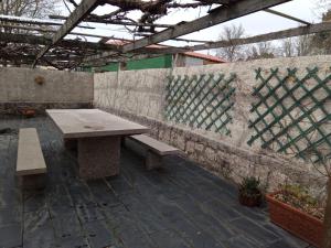 a patio with a wooden table and benches at Casa Raposeira in Ourense