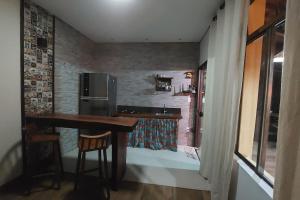 una cucina con tavolo e frigorifero di Chalé Beira Rio Cipó a Serra do Cipo Altre 42 foto