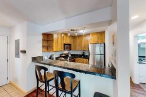 a kitchen with wooden cabinets and a counter with bar stools at Alpine Escape in Edwards