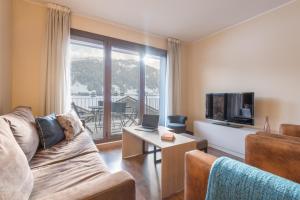 a living room with a couch and a television at Pierre & Vacances Andorra Bordes d’Envalira in Bordes d´Envalira 