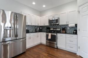 a kitchen with white cabinets and a stainless steel refrigerator at St Augustine Rose Ocean Heated Private Pool in Saint Augustine
