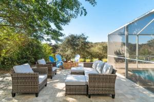 a patio with wicker furniture and chairs next to a pool at St Augustine Rose Ocean Heated Private Pool in Saint Augustine