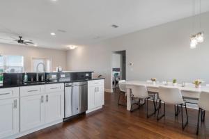 a kitchen with white cabinets and a table and chairs at St Augustine Rose Ocean Heated Private Pool in Saint Augustine