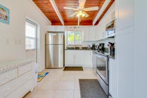 a kitchen with white cabinets and a ceiling fan at Downhome Cabin by the Canal in Key Colony Beach