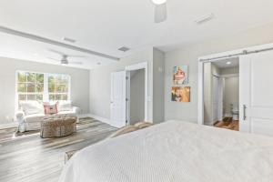 a white bedroom with a bed and a couch at Waters Edge at Cortez in Saint Augustine