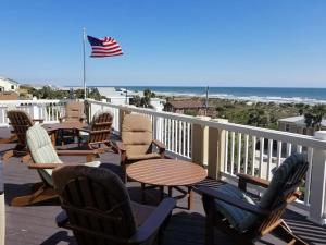 a deck with chairs and tables and an american flag at The Sand Castle Heated Pool Atlantic Ocean in St. Augustine