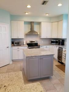 a kitchen with white cabinets and a counter top at The Sand Castle Heated Pool Atlantic Ocean in St. Augustine +31 photos