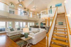 a living room with a white couch and a staircase at The Sand Castle Heated Pool Atlantic Ocean in St. Augustine