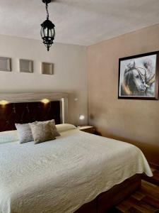 1 dormitorio con 1 cama y una foto de un caballo en Cabañas Rancho San Jorge, en Bernal