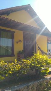 a yellow house with a door and some flowers at Pousada Barriga da Lua in Serra do Cipo