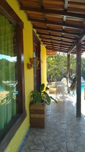 a yellow house with a porch with a patio at Pousada Barriga da Lua in Serra do Cipo