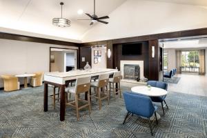 a living room with a bar and chairs and a fireplace at Homewood Suites by Hilton Portsmouth in Portsmouth