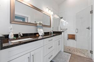 a bathroom with a sink and a mirror and a shower at Cobalt Cottage History at your doorstep in St. Augustine