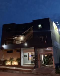 a black and white building with a garage at night at Hotel JK Buenópolis in Buenópolis