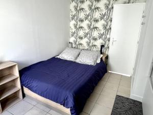 a bedroom with a bed with a blue comforter at Appartement avec extérieur in Loos