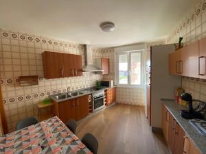 a kitchen with wooden cabinets and a table in it at Lar dos Galos in Bueu