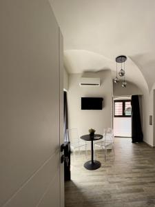 einen Flur mit einem Tisch und Stühlen in einem Zimmer in der Unterkunft VICOLO SAN GAETANO -luxury rooms- in Catania