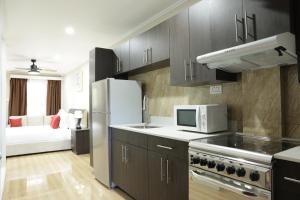 a kitchen with a refrigerator and a microwave at Myah's Hotel in Brighton Village