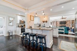 a large kitchen with a counter and stools in it at Lighthouse Retreat Island Beach Pool in Saint Augustine