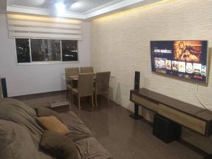 a living room with a couch and a tv on a wall at Apartamento Top Expo Center Norte Paulista Centro in Sao Paulo