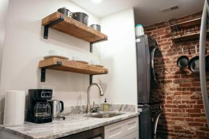 a kitchen with a sink and a brick wall at Fells Point Charm Doubled! in Baltimore