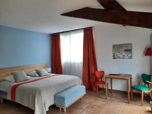 a bedroom with a bed and a table and chairs at Le Clos des Chênes in Lagarde-Paréol