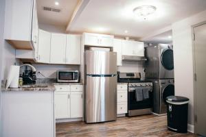 a kitchen with white cabinets and a stainless steel refrigerator at Fells Point Charm Doubled! in Baltimore
