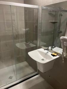La salle de bains est pourvue d'un lavabo et d'une douche en verre. dans l'établissement Crystal Woods, à Bakuriani