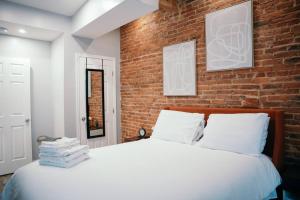 a bedroom with a brick wall and a bed at Fells Point Charm Doubled! in Baltimore