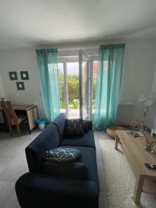 a living room with a blue couch and a table at Studio meuble Kenaya 29m2. in Saint-Étienne-du-Rouvray