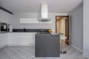 a kitchen with white cabinets and a counter top at Sunny Beachside Haven 2 Bd In The Marina District in Barcelona