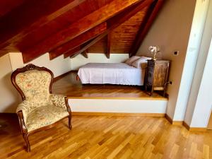a bedroom with a bed and a chair at Paradise - nature and wellness in Pino Torinese