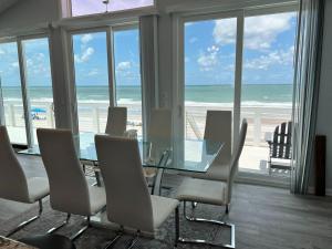 a dining room with a table and chairs and the beach at Serenity One 100 percent Oceanfront 6 Bedrooms in Ponte Vedra Beach