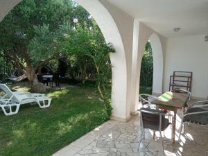 a patio with chairs and tables and a garden at KATY&MLADEN in Baška